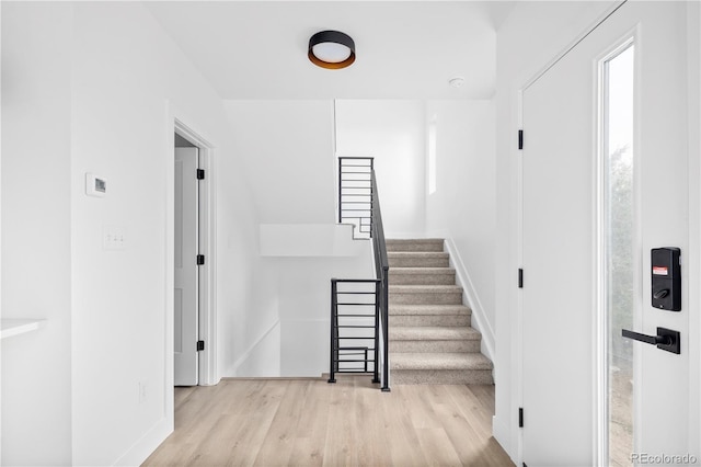 stairway featuring baseboards and wood finished floors