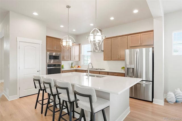 21209 E 62nd Ave, Aurora, CO 80019 - kitchen with appliances with stainless steel finishes, light wood finished floors, light countertops, an island with sink, and recessed lighting