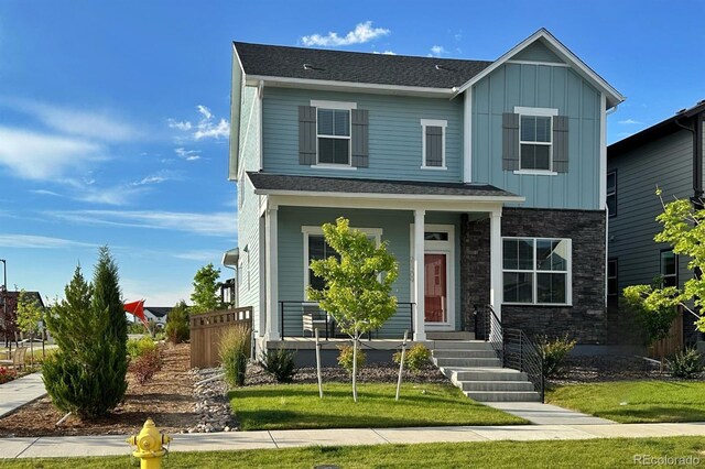 21209 E 62nd Ave, Aurora, CO 80019 - view of front of house with board and batten siding, covered porch, and stone siding