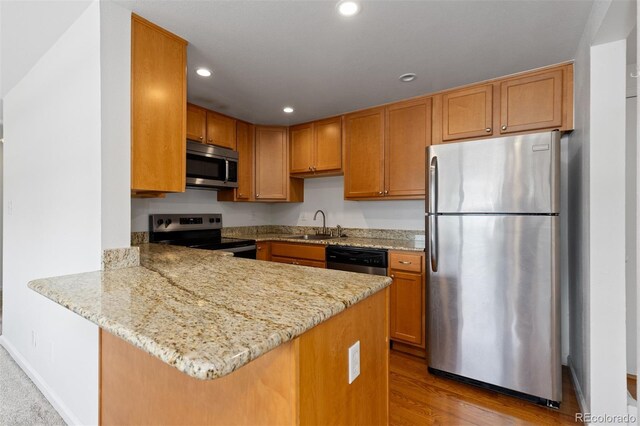 745 Thomas Dr Unit 2, Boulder, CO 80303 - kitchen with stainless steel appliances, a peninsula, light stone countertops, recessed lighting, and wood finished floors