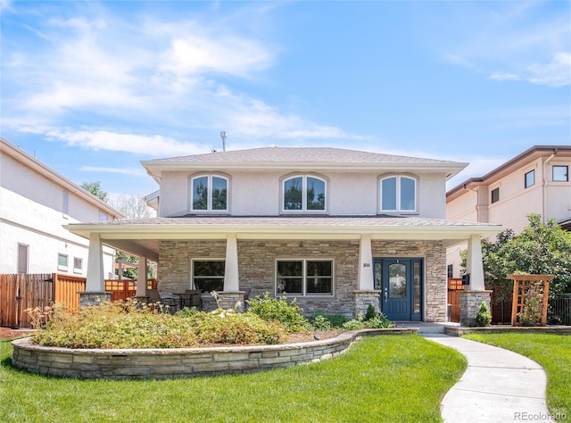 view of front of home featuring covered porch, fence, stone siding, stucco siding, and a front lawn