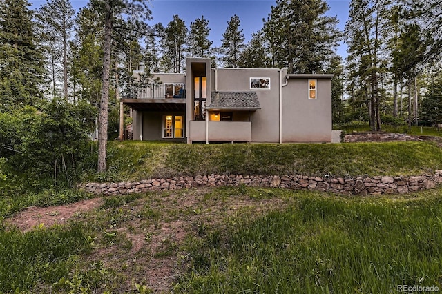 back of house with a wooden deck and stucco siding