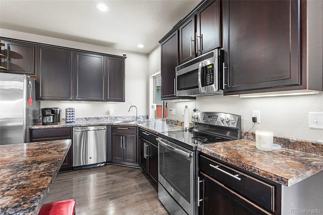 18651 E 53rd Ave, Denver, CO 80249 - kitchen with appliances with stainless steel finishes, a sink, recessed lighting, dark wood-style flooring, and dark brown cabinets