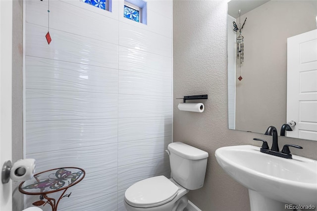 18651 E 53rd Ave, Denver, CO 80249 - bathroom with toilet, a sink, and a textured wall