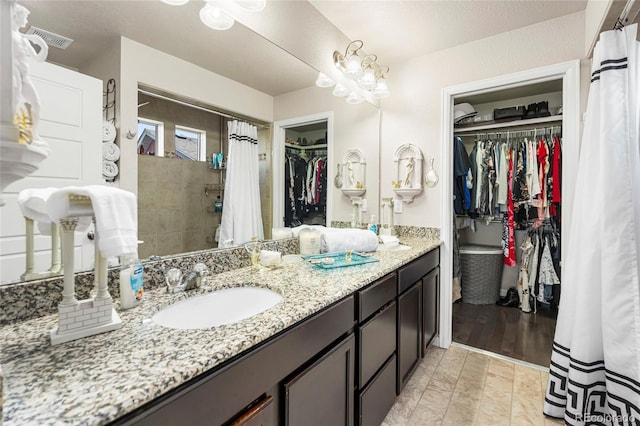 18651 E 53rd Ave, Denver, CO 80249 - full bath with double vanity, a spacious closet, and tiled shower