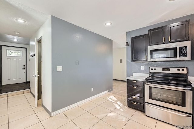 3320 Simmelink Loop, Colorado Springs, CO 80916 - kitchen featuring stainless steel appliances, light tile patterned flooring, light countertops, recessed lighting, and baseboards
