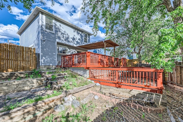 3320 Simmelink Loop, Colorado Springs, CO 80916 - rear view of property with a deck, a fenced backyard, and a vegetable garden