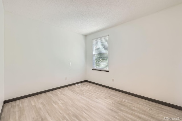 3320 Simmelink Loop, Colorado Springs, CO 80916 - unfurnished room featuring light wood finished floors, baseboards, and a textured ceiling