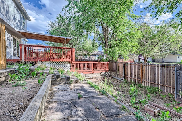 3320 Simmelink Loop, Colorado Springs, CO 80916 - fenced backyard with a wooden deck, a vegetable garden, and a patio area