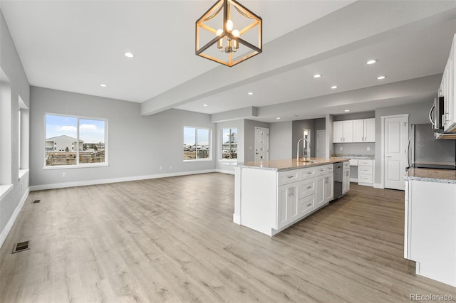 kitchen with decorative light fixtures, white cabinetry, and a wealth of natural light