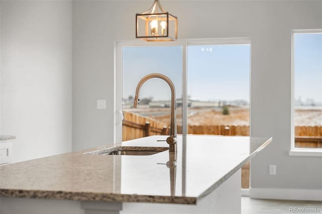 kitchen featuring a chandelier, pendant lighting, light wood-type flooring, and a healthy amount of sunlight