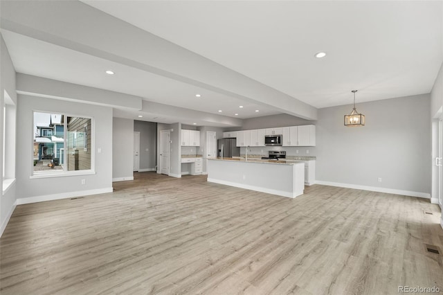 unfurnished living room with sink and light hardwood / wood-style flooring