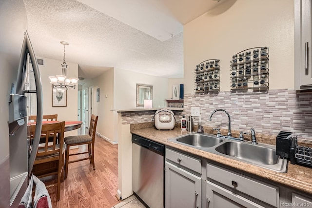 7881 Allison Way Unit 303, Arvada, CO 80005 - kitchen featuring stainless steel dishwasher, fridge, decorative backsplash, light wood-type flooring, and a chandelier