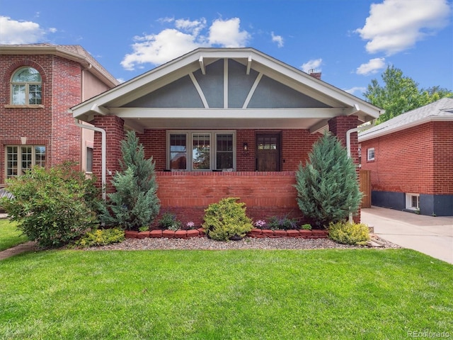 660 S Clarkson St, Denver, CO 80209 - view of front facade with brick siding, a front lawn, and covered porch