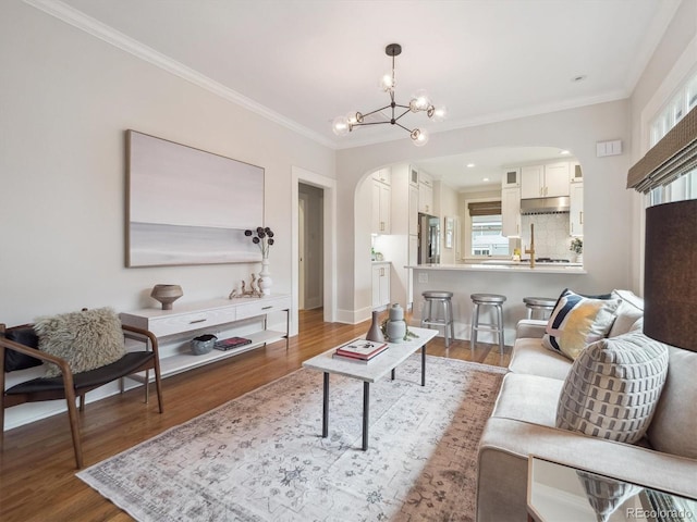 660 S Clarkson St, Denver, CO 80209 - living area with arched walkways, wood finished floors, ornamental molding, a chandelier, and healthy amount of natural light