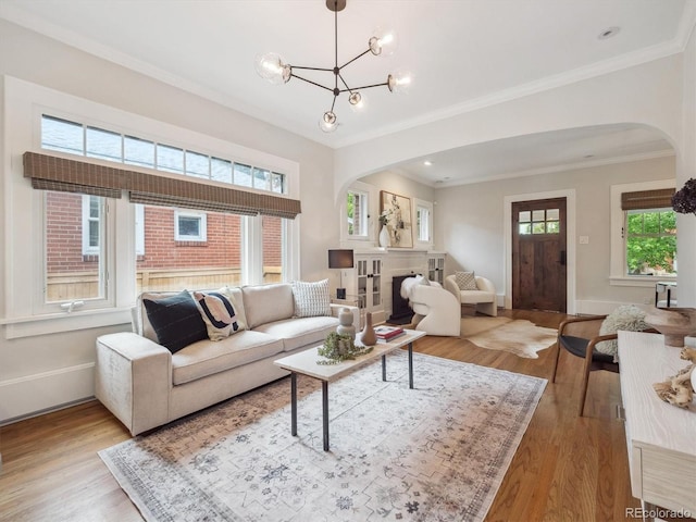 660 S Clarkson St, Denver, CO 80209 - living area with arched walkways, wood finished floors, ornamental molding, a chandelier, and baseboards