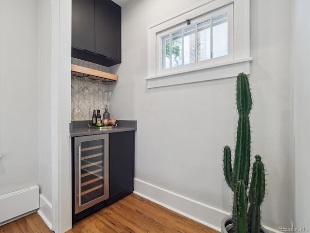 660 S Clarkson St, Denver, CO 80209 - indoor dry bar featuring beverage cooler, decorative backsplash, wood finished floors, and baseboards