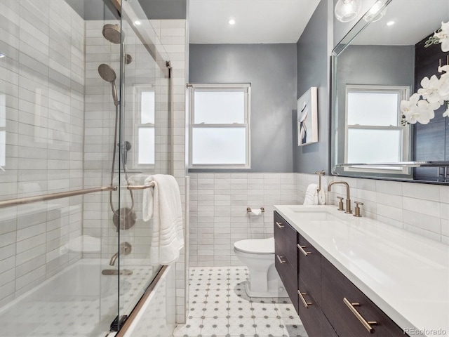 660 S Clarkson St, Denver, CO 80209 - full bath with vanity, toilet, healthy amount of natural light, tile walls, and tiled shower / bath combo