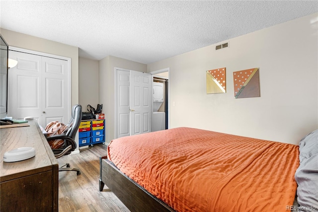 16001 E Alaska Pl Unit 12, Aurora, CO 80017 - bedroom with wood finished floors, a closet, a textured ceiling, and an office area