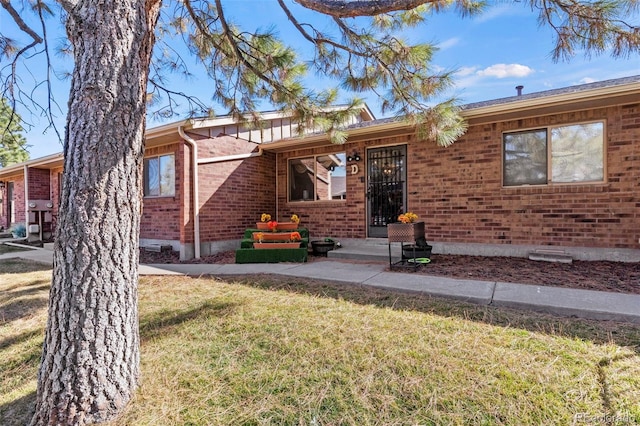 ranch-style house featuring brick siding and a front yard