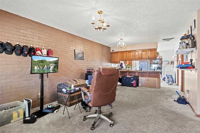 office featuring a textured ceiling, an inviting chandelier, brick wall, and carpet