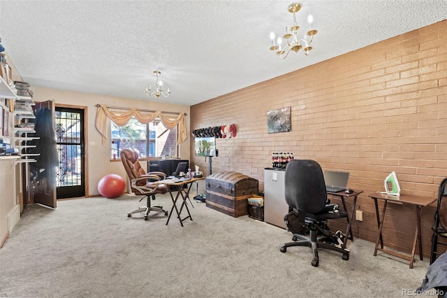 office area featuring carpet floors, a textured ceiling, an inviting chandelier, and brick wall