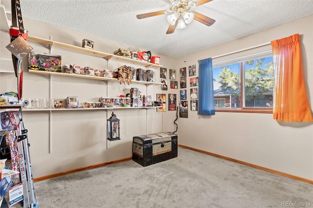 misc room featuring a ceiling fan, baseboards, carpet floors, and a textured ceiling