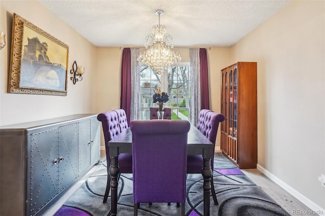 7925 W Layton Ave Unit 500, Littleton, CO 80123 - dining area with a chandelier, wood finished floors, a textured ceiling, and baseboards