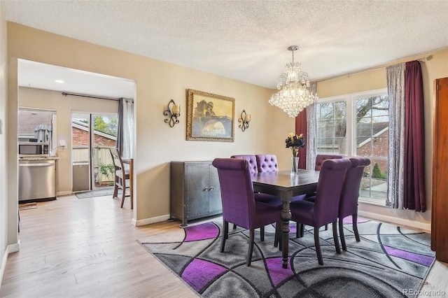 7925 W Layton Ave Unit 500, Littleton, CO 80123 - dining space featuring a chandelier, light wood-style floors, baseboards, and a textured ceiling