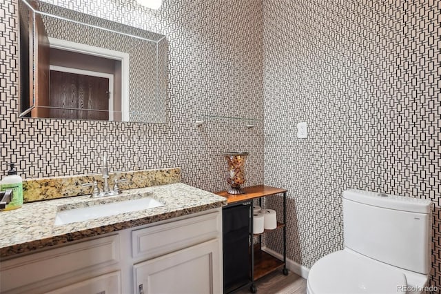 7925 W Layton Ave Unit 500, Littleton, CO 80123 - half bathroom featuring toilet, vanity, decorative backsplash, and wood finished floors