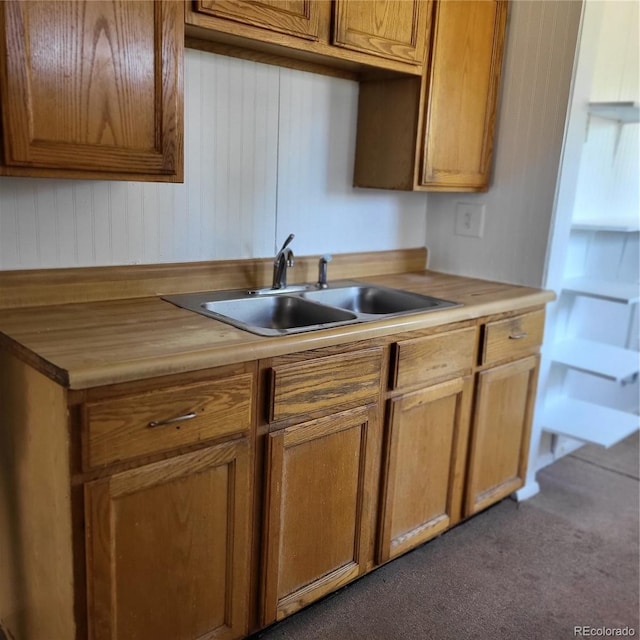 256 S 2nd Ave, Brighton, CO 80601 - kitchen featuring dark carpet, brown cabinetry, and wooden walls