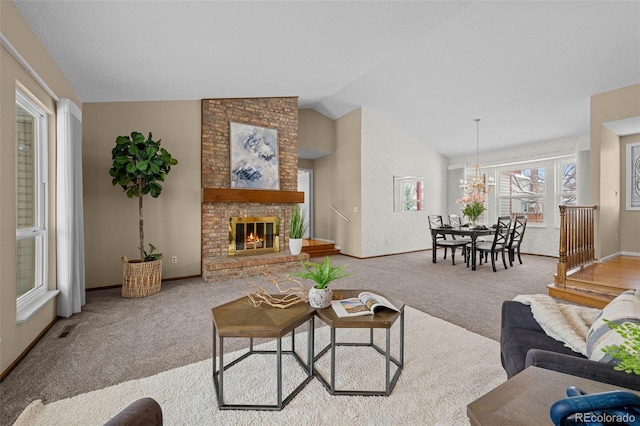 carpeted living room featuring a fireplace, lofted ceiling, and a notable chandelier