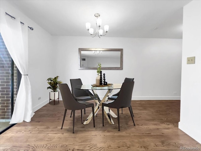 dining room with wood finished floors, baseboards, and a chandelier