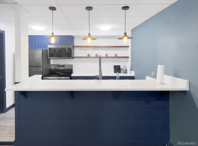 kitchen with appliances with stainless steel finishes, a breakfast bar area, tasteful backsplash, light countertops, and blue cabinets