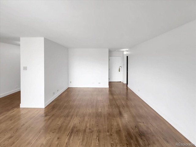 spare room with wood finished floors and baseboards