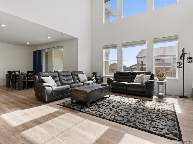 living area featuring a wealth of natural light, recessed lighting, baseboards, and wood finished floors