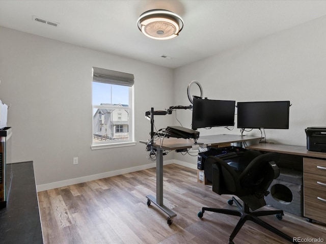 office area featuring visible vents, baseboards, and wood finished floors