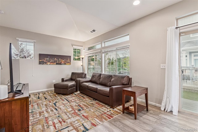 18112 E 104th Way, Commerce City, CO 80022 - living room featuring baseboards, light wood-style flooring, and vaulted ceiling
