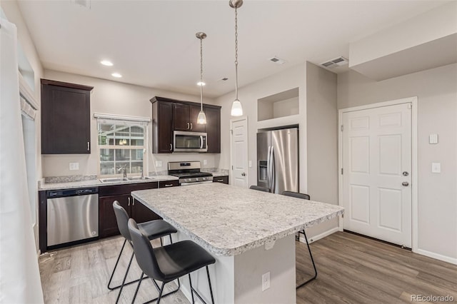 18112 E 104th Way, Commerce City, CO 80022 - kitchen with stainless steel appliances, a kitchen breakfast bar, a sink, dark brown cabinetry, and light countertops