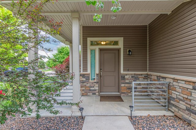 18112 E 104th Way, Commerce City, CO 80022 - property entrance with a porch and stone siding