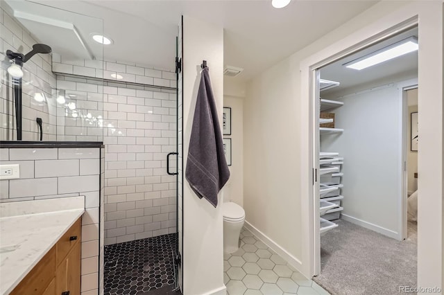 bathroom with toilet, recessed lighting, vanity, baseboards, and a shower stall