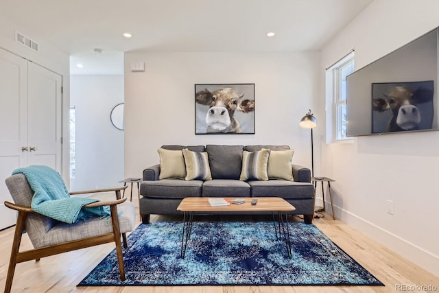 living area with recessed lighting, wood finished floors, visible vents, and baseboards