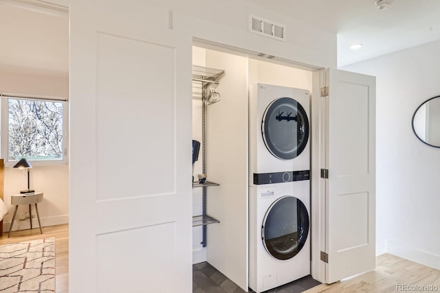 4441 N Meade St, Denver, CO 80211 - clothes washing area featuring stacked washer / drying machine, laundry area, baseboards, wood finished floors, and visible vents