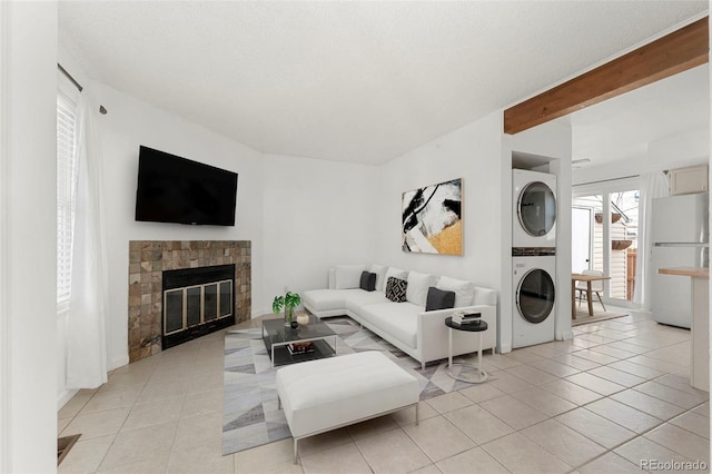 tiled living room with beamed ceiling and stacked washer and dryer