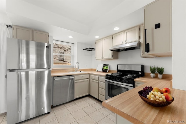 kitchen featuring cream cabinets, sink, light tile patterned floors, and stainless steel appliances