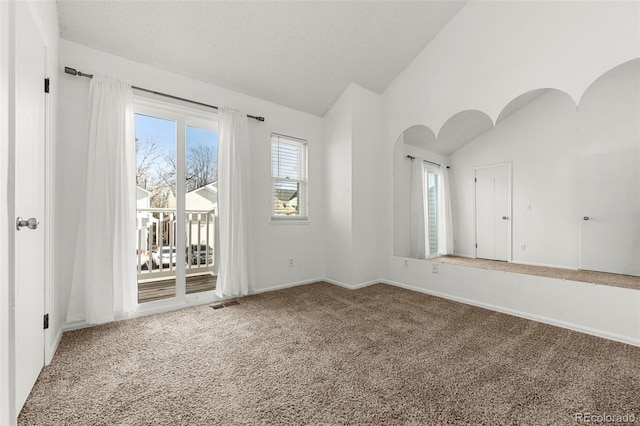 carpeted spare room with lofted ceiling