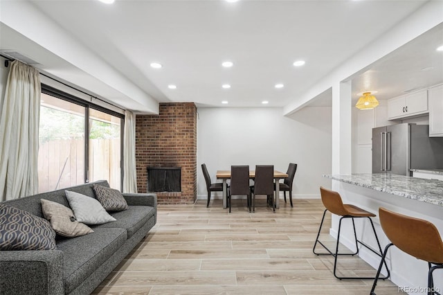 7995 E Mississippi Ave Unit A4, Denver, CO 80247 - living area featuring recessed lighting, baseboards, a brick fireplace, and light wood-style flooring