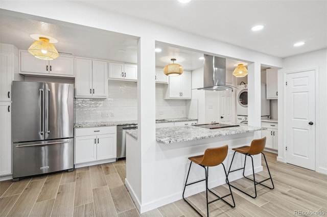 7995 E Mississippi Ave Unit A4, Denver, CO 80247 - kitchen with appliances with stainless steel finishes, ventilation hood, wood tiled floors, white cabinetry, and recessed lighting