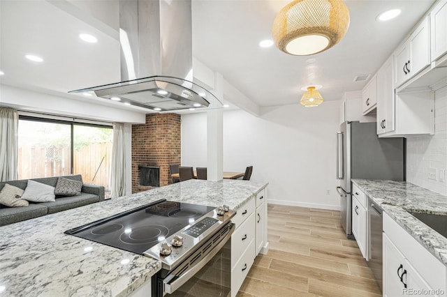 7995 E Mississippi Ave Unit A4, Denver, CO 80247 - kitchen with stainless steel appliances, island range hood, light wood-type flooring, white cabinetry, and light stone counters