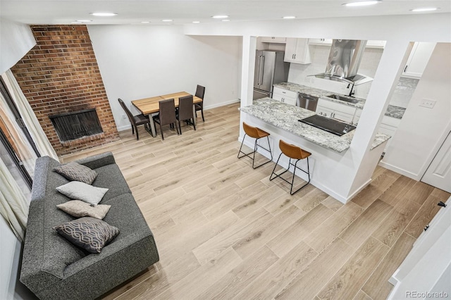 7995 E Mississippi Ave Unit A4, Denver, CO 80247 - kitchen with appliances with stainless steel finishes, a breakfast bar area, light wood-type flooring, a sink, and recessed lighting